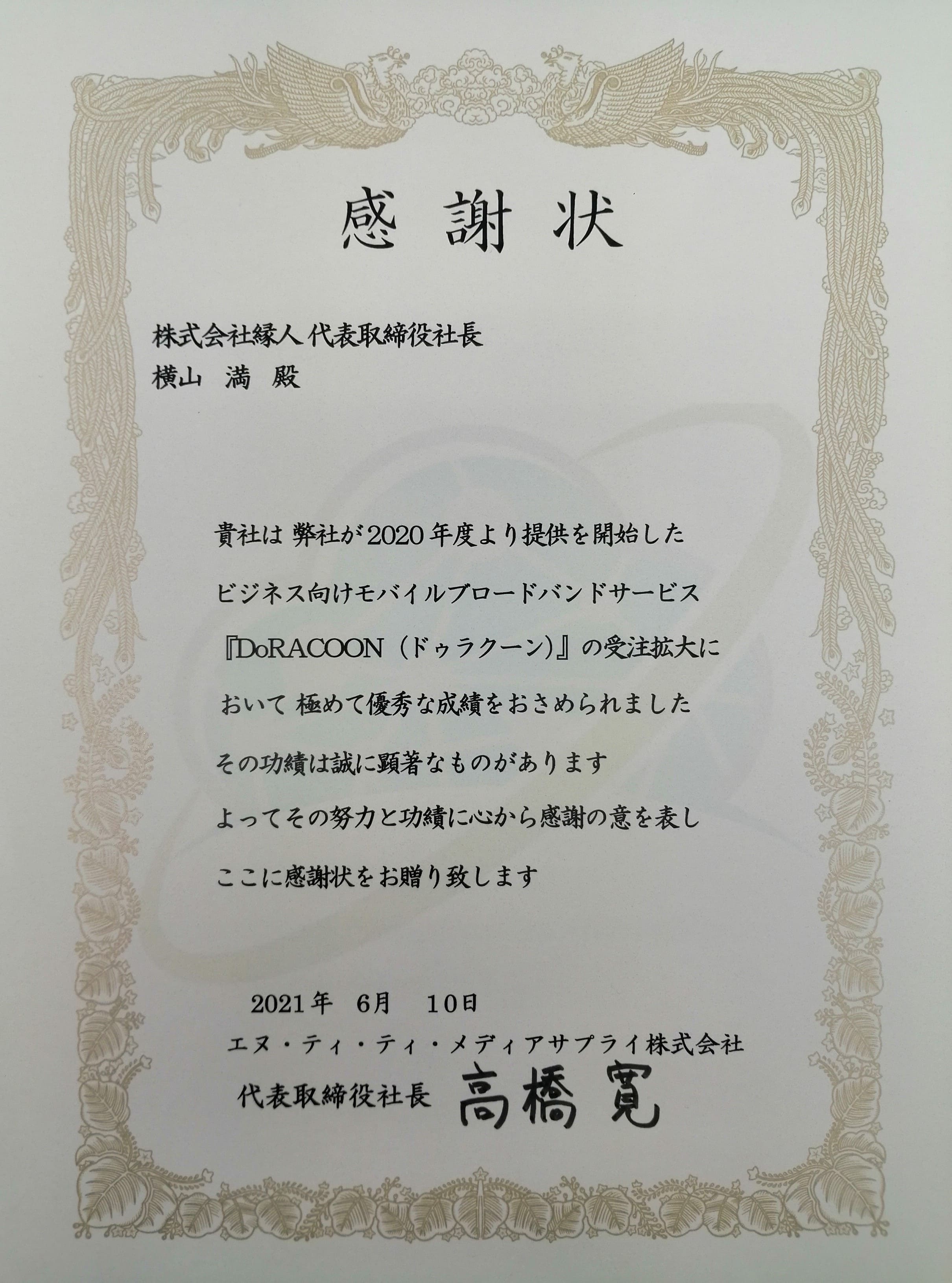 感謝状　株式会社縁人代表取締役社長横山満殿　貴社は弊社が2020年度より提供を開始したビジネス向けモバイルブロードバンドサービス「DoRACOON（ドゥラクーン）」の受注拡大において極めて優秀な成績をおさめられました その功績は誠に顕著なものがあります よってその努力と功績に心から感謝の意を表しここに感謝状をお贈り致します 2021年6月10日 エヌ・ティ・ティ・メディアサプライ株式会社 代表取締役社長高橋寛